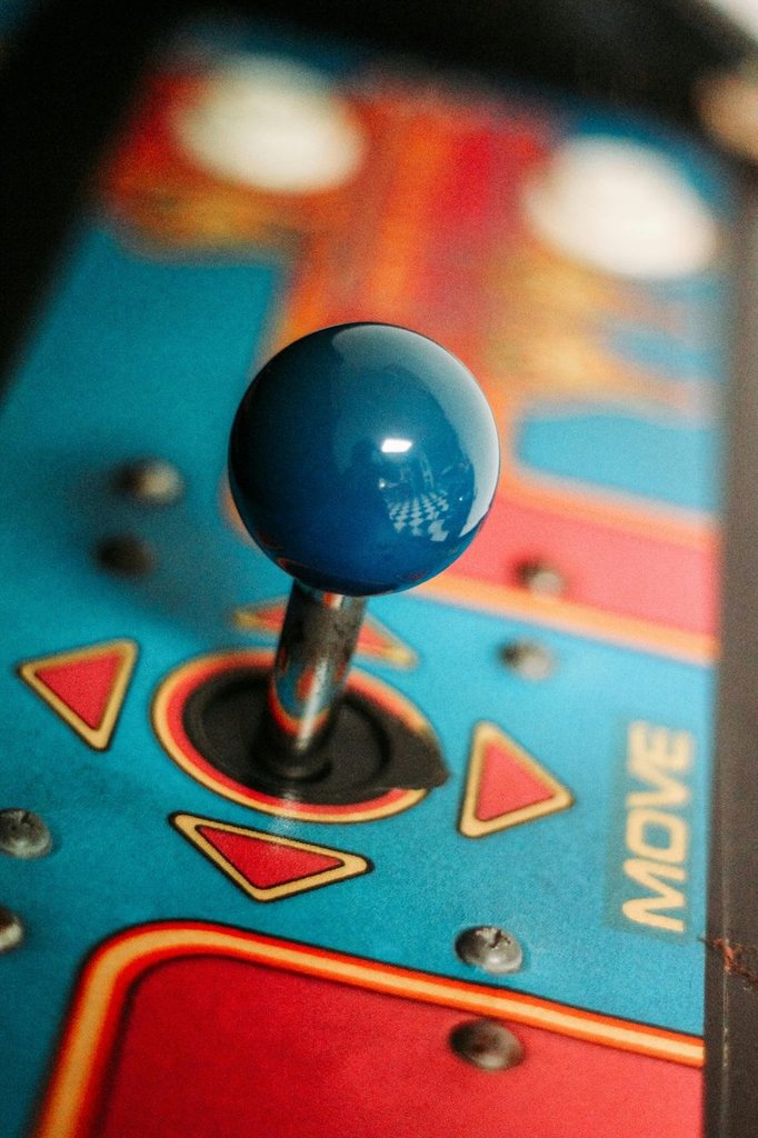 Joystick eines klassischen Arcade-Spielautomaten in Blau, Nahaufnahme beim Retro-Gaming